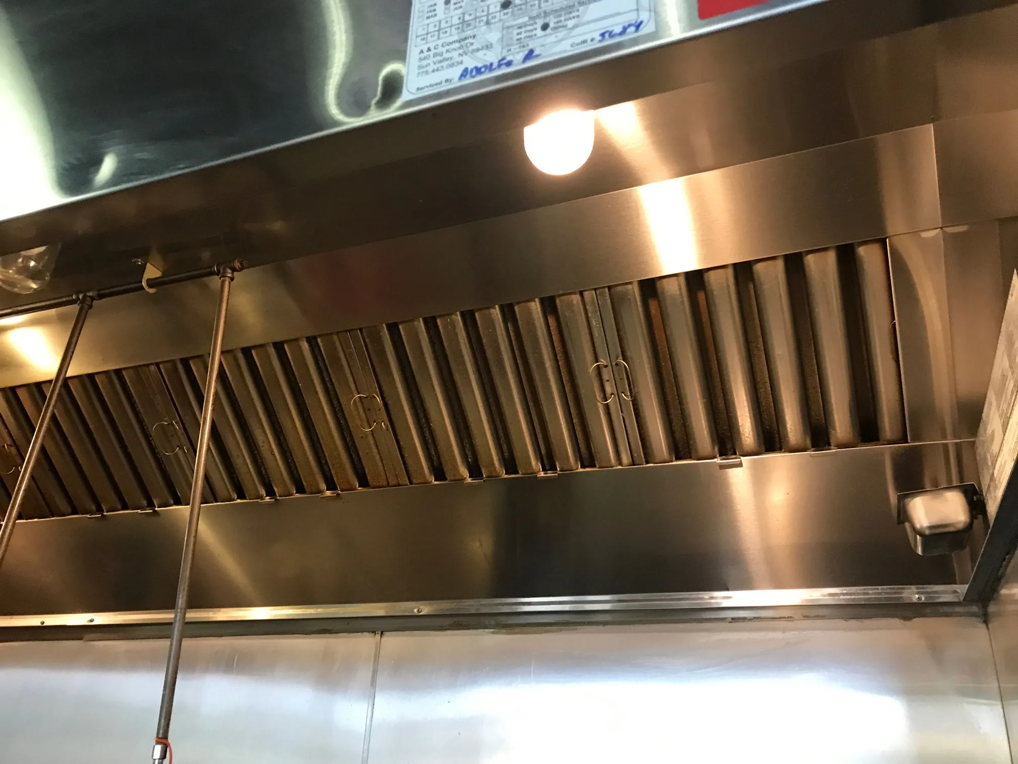 Before and after hood cleaning comparison showing grease removal results