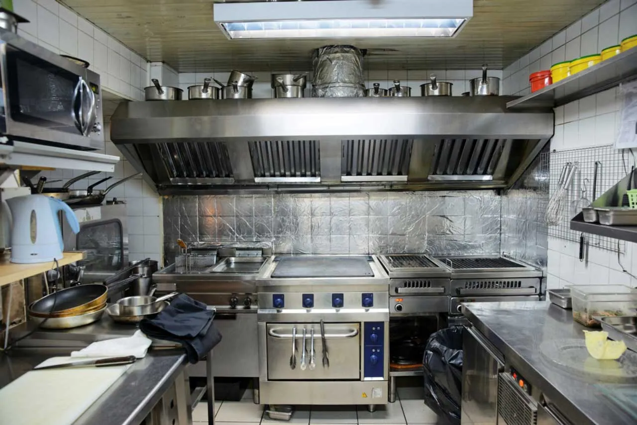 Professional hood cleaning technician servicing a restaurant exhaust system in San Diego